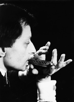Claude Garden playing the chromatic harmonica, black-and-white photo